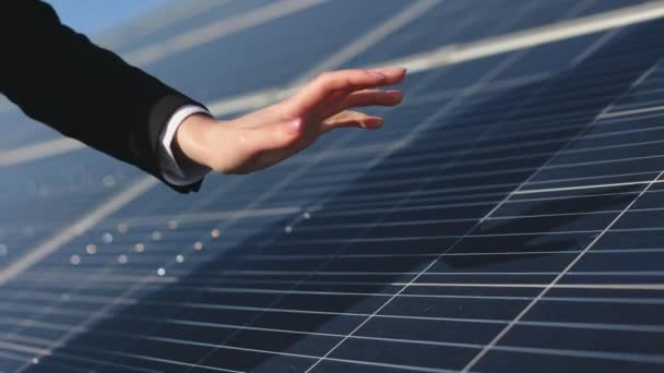 Uma engenheira está tocando a superfície dos painéis solares com a mão. Tiroteio de perto. 4K — Vídeo de Stock