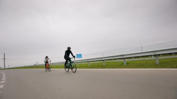 Os ciclistas estão a treinar na pista. Treino na estação fria. A disparar de longe. 4K — Vídeo de Stock