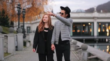 Bir adam ve bir kadın rıhtımda yürüyorlar. - Konuşuyorlar. Şık giyinmişler. 4K