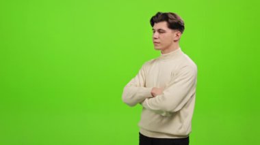 Adam ayakta duruyor ve kameraya bakıyor. Hayal kırıklığı içinde elini kaldırıyor ve yüzünü örtüyor. O, yeşil bir arka planın üzerinde duruyor. Yeşil ekran. 4K