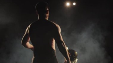 Tayt giyen bir adam sahneye çıkacakmış. Kazananlar Kupası 'nı kaldırıyor. Spot ışıkları onun üzerinde parlıyor. 4K