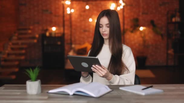 Bir kadın tablet üzerinde çalışıyor. Ofisindeki bir masada oturuyordu. 4K — Stok video