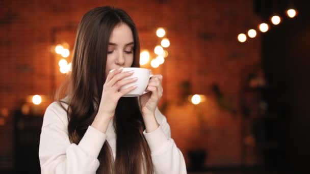 Bir kadın ev ofisinde oturuyor. O bir fincan tutuyor ve çay içiyor. Portre çekimi. 4K — Stok video