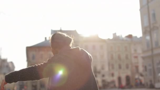 Un homme barbu heureux écoute de la musique et danse émotionnellement. Il agite les mains. Il portait un casque. Tirer par derrière. Le soleil brille. 4K — Video