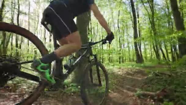 Un ciclista sta cavalcando attraverso le colline nei boschi. Indossa l'attrezzatura da ciclismo. Sparo da un lato. 4K — Video Stock