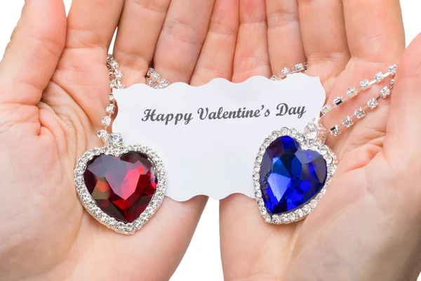红色和蓝色的珠宝心与手上的情人节卡 — 图库照片