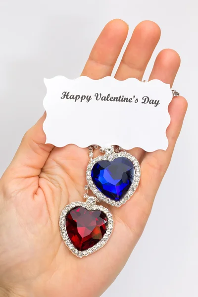 Hand visar röda och blå smycken hjärtan för valentine — Stockfoto