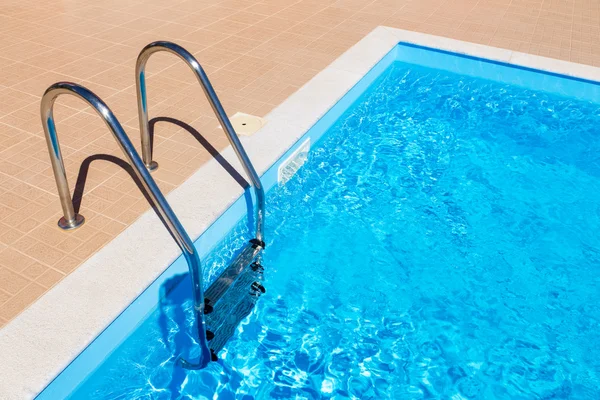 Blått svømmebasseng med stige – stockfoto