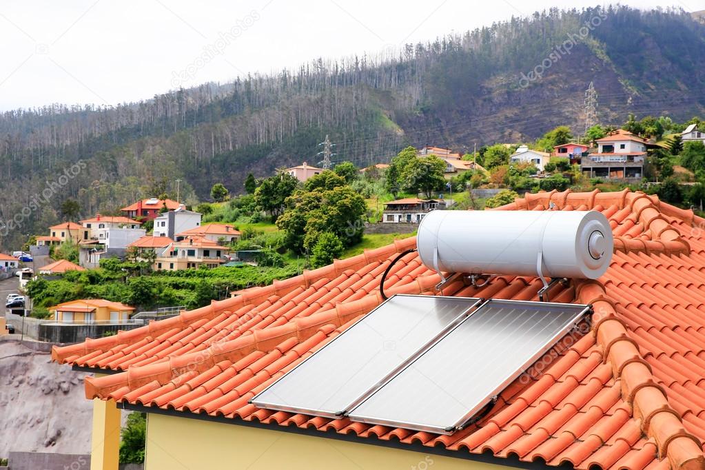 Water boiler with solar panels on roof of house