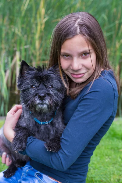Kolunda siyah köpek taşıyan kız — Stok fotoğraf