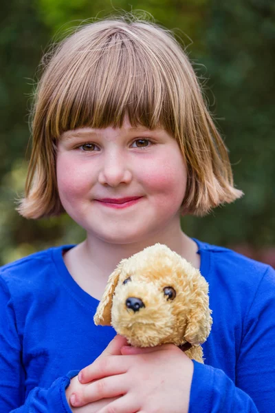 Young girl holding stuffed dog — Stock Photo, Image