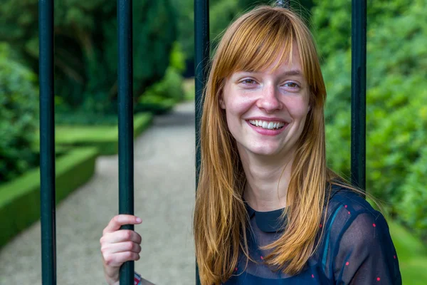 Roodharige meisje lachen houden bar poort — Stockfoto