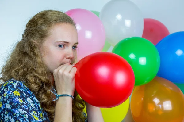 Genç kız şişirme üfleme renkli balonlar — Stok fotoğraf