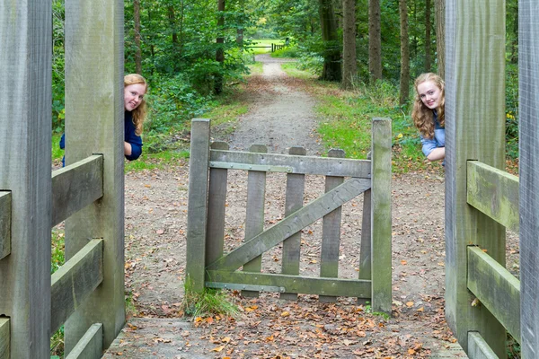 Dvě dívky skrývá u vstupu turistické stezky v přírodě — Stock fotografie