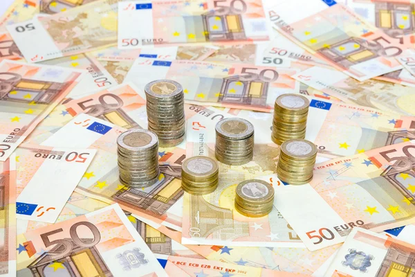 Piles de pièces en euros debout sur les billets en euros — Photo