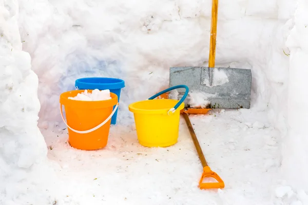 Hut with walls of snow and colorful buckets plus snowplow — Stock Photo, Image