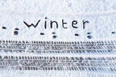 Word winter and tire tracks in snow clipart