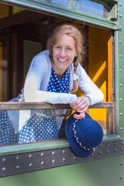 Dutch woman in old-fashioned clothes holding hat in train window