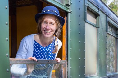 Dutch woman in old-fashioned clothes in window of steam train
