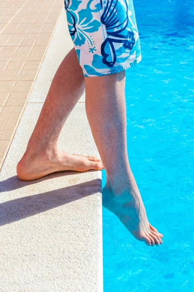 Legs with foot feeling water temparature in swimming pool — Stock Photo, Image