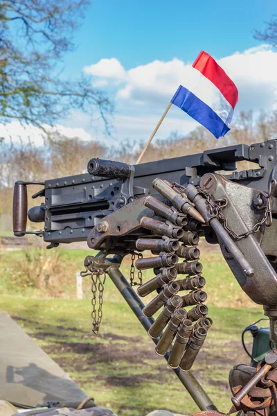 Military machine gun with bullets and dutch flag — Zdjęcie stockowe