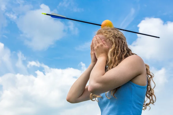 Teenager-Mädchen spürt Angst mit Apfel und Pfeil auf dem Kopf — Stockfoto