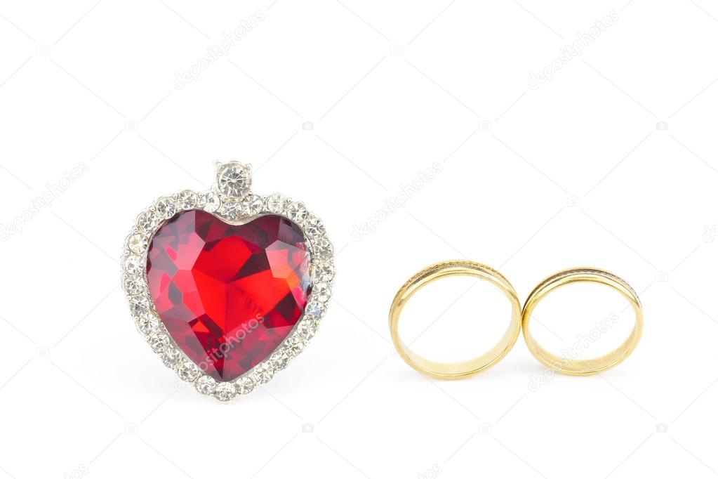Red jewelry heart and two golden rings