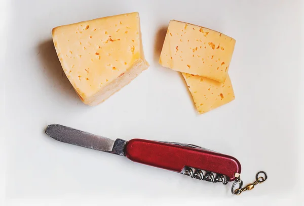 Bir kesme tahtası üzerinde bıçak ile peynir