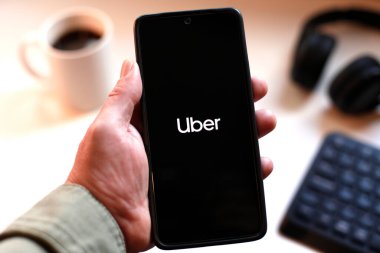 VALENCIA, İspanya 01.27, 2026. Bir el, canlı yeşil ekranda çizgi logosunu gösteren akıllı telefonu kavrıyor. Modern bir çalışma ortamında mobil mesajlaşma, bağlantı ve dijital iletişimi öneriyor..