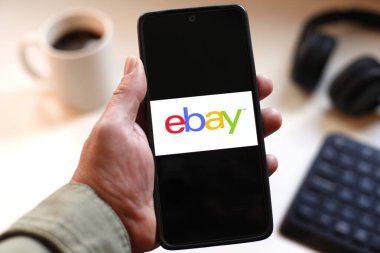 VALENCIA, İspanya 01.27, 2026. Bir el, canlı yeşil ekranda çizgi logosunu gösteren akıllı telefonu kavrıyor. Modern bir çalışma ortamında mobil mesajlaşma, bağlantı ve dijital iletişimi öneriyor..