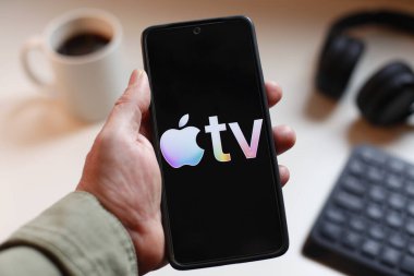 VALENCIA, İSPA 01.27, 2026: Bir el, modern bir çalışma ortamında mobil mesajlaşma, bağlantı ve dijital iletişimi öneren canlı yeşil ekranda hat logosunu gösteren bir akıllı telefonu kavrıyor.