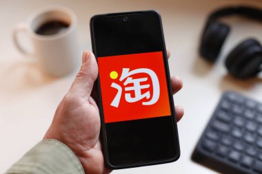 VALENCIA, İSPA 01.27, 2026: Bir el, modern bir çalışma ortamında mobil mesajlaşma, bağlantı ve dijital iletişimi öneren canlı yeşil ekranda hat logosunu gösteren bir akıllı telefonu kavrıyor.