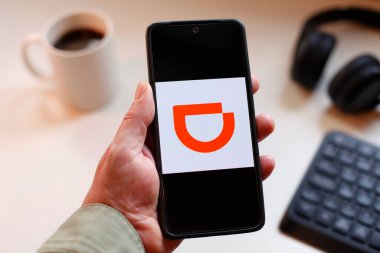 VALENCIA, İspanya 01.27, 2026. Bir el, canlı yeşil ekranda çizgi logosunu gösteren akıllı telefonu kavrıyor. Modern bir çalışma ortamında mobil mesajlaşma, bağlantı ve dijital iletişimi öneriyor..