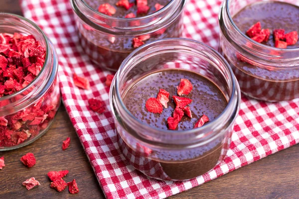 Choklad chia utsäde puddingar med torkade jordgubbar Stockbild