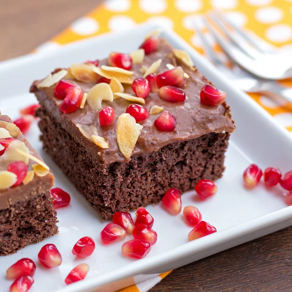 Chocolate cake decorated with pomegranate and almond — Stock Photo, Image