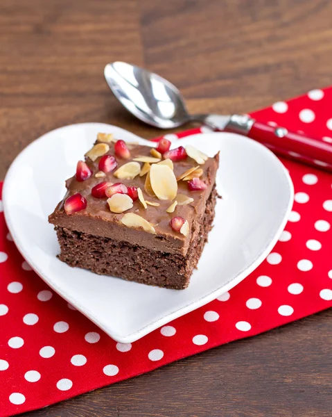 Chocolate cake decorated with pomegranate and almond — Stock Photo, Image