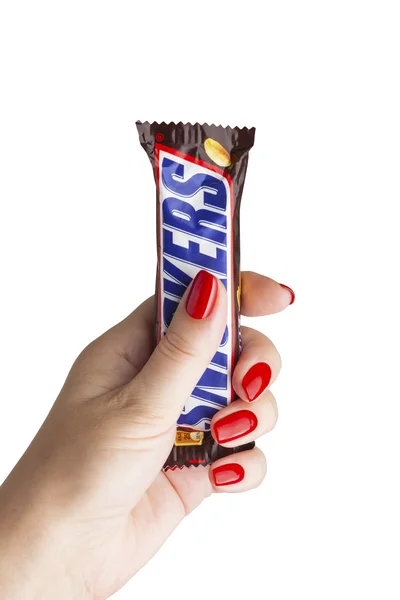 Barra de chocolate Snickers a uma mão feminina . — Fotografia de Stock