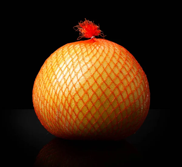 出荷中のオレンジ色のパッケージのポメロ柑橘類黒の背景に隔離されたクローズアップ — ストック写真
