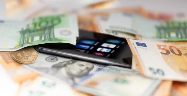 Mobil bankacılık ve finans kavramı: uygulamalı akıllı telefon, avro, Amerikan doları banknotları ve bitcoin. İş geçmişi. Bulanık konsept