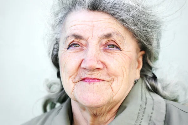 Feliz cara de abuela sobre un fondo gris — Foto de Stock