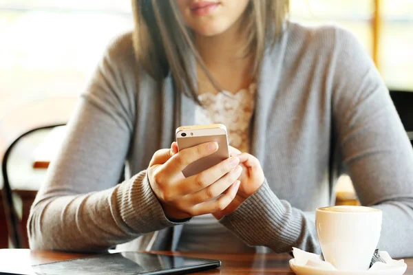 Женщина с мобильником в кафе — стоковое фото