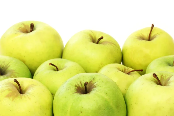 Een heleboel groene appels op een witte achtergrond — Stockfoto