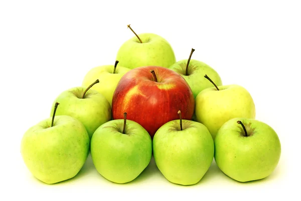 Trojúhelník postavený ze zelených jablek a červené jablko v centru — Stock fotografie