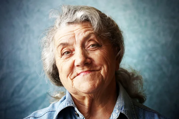 Šťastná babička portrét na modrém pozadí — Stock fotografie