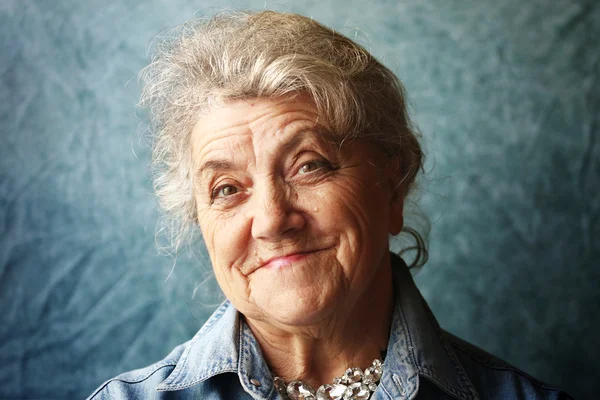 Feliz retrato de la abuela sobre un fondo azul Fotos de stock libres de derechos