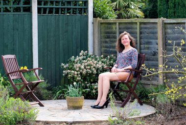 Olgun ve çekici bir esmer kadının cazibeli bakışlarını yakalayarak bahçede biraz temiz havanın tadını çıkarıyorum..