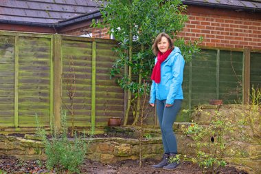 Yeni yılda dikilen iki yeni armut ağacının yanında duran bir dişiyi yakalamak.