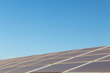 Mavi gökyüzü arkaplanındaki güneş paneli. Güneş pili çiftliğinin manzarası. Daha iyi bir gelecek için temiz teknoloji.