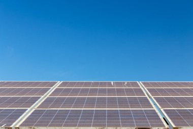 Mavi gökyüzü arkaplanındaki güneş paneli. Güneş pili çiftliğinin manzarası. Daha iyi bir gelecek için temiz teknoloji.