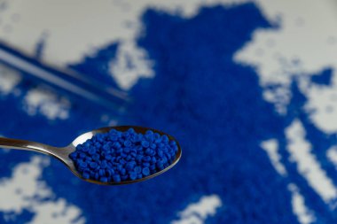 Yeşil eldivenli elindeki plastik boncuklar. polimer boncuklar. Dünyanın plastik azaltma politikası. Beyaz arkaplanda plastik.